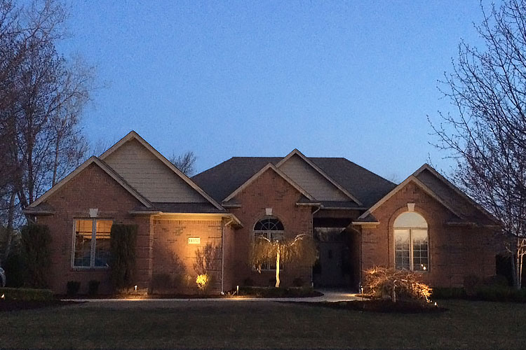 home lit by landscape lighting